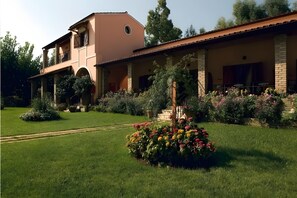 A two-story building with a garden in front.