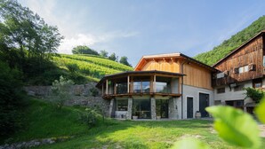 Una moderna casa a due piani con fondamenta in pietra, struttura in legno e un balcone.