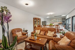 Una sala de estar con sofás de cuero, una mesa de centro y un comedor con mesa y sillas.