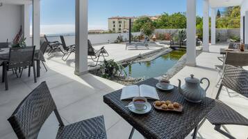 Un espace extérieur aménagé, abrité et doté d’une piscine, d’un coin repas et offrant une vue sur le paysage urbain.