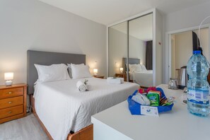 A hotel room with a bed, a nightstand, a desk, and a large water bottle. - Studio 'Mariana' with Atlantic View, Culinary Experience and Unique Hospitality (Gaula)