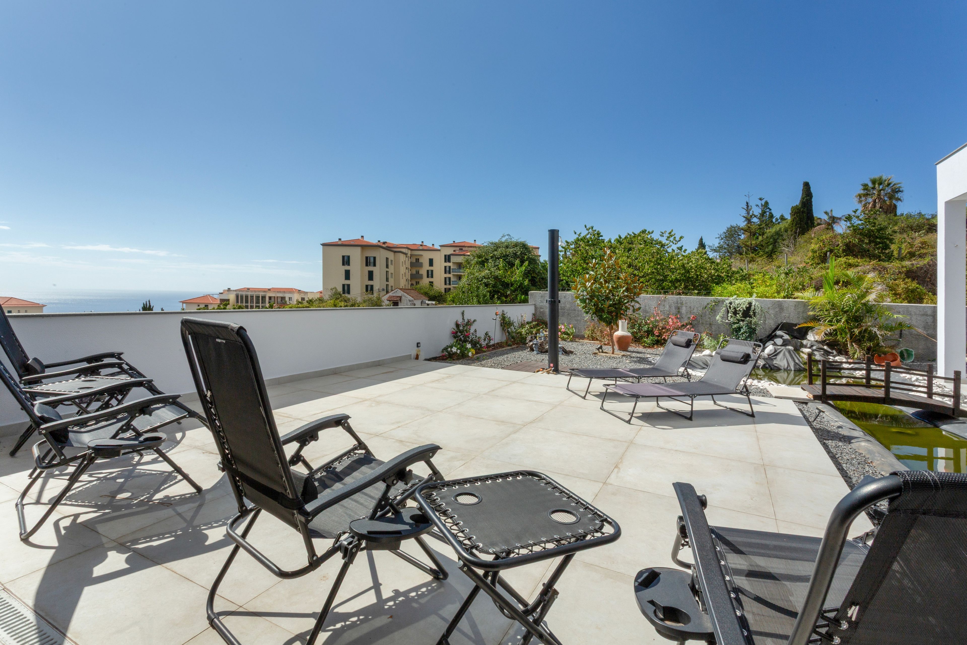 Terraza en la azotea con mobiliario exterior y vista al mar.