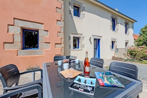 Une table avec des chaises, une bouteille et un magazine.