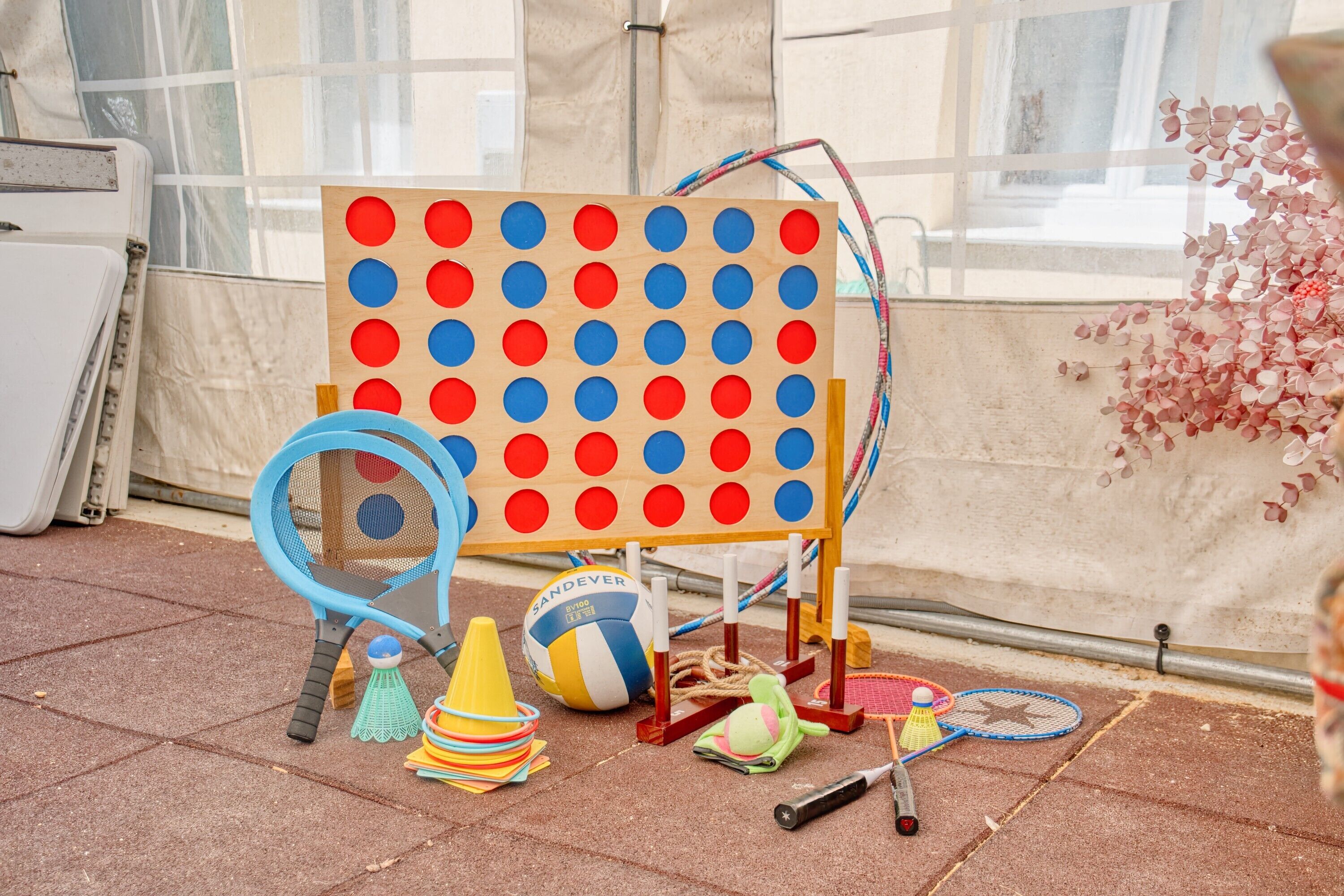 A beach-themed play area with a pinboard game, beach balls, and badminton rackets.