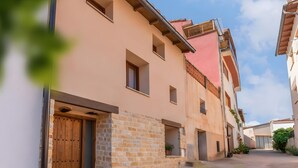 Una stretta via fiancheggiata da edifici con muri in pietra e porte in legno.