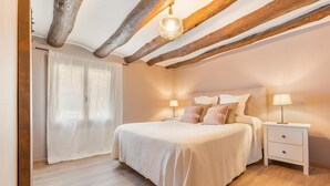 Una camera da letto con un letto, comodini e un soffitto in legno.