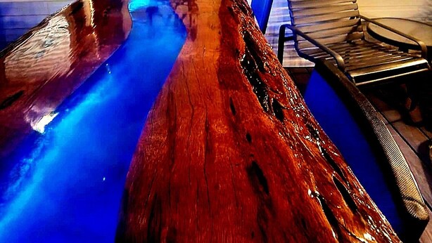 Ein Holztisch mit einem Schild, auf dem 'Welcome to the Lake' steht.