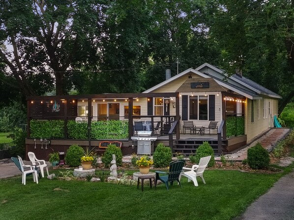 A cozy lodge with a deck, outdoor seating, and a barbecue area.