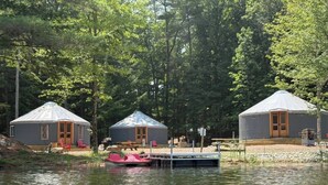 Three yurts by a lake surrounded by trees. - Shoreline Yurt @ Daggett Lake (Warrensburg)