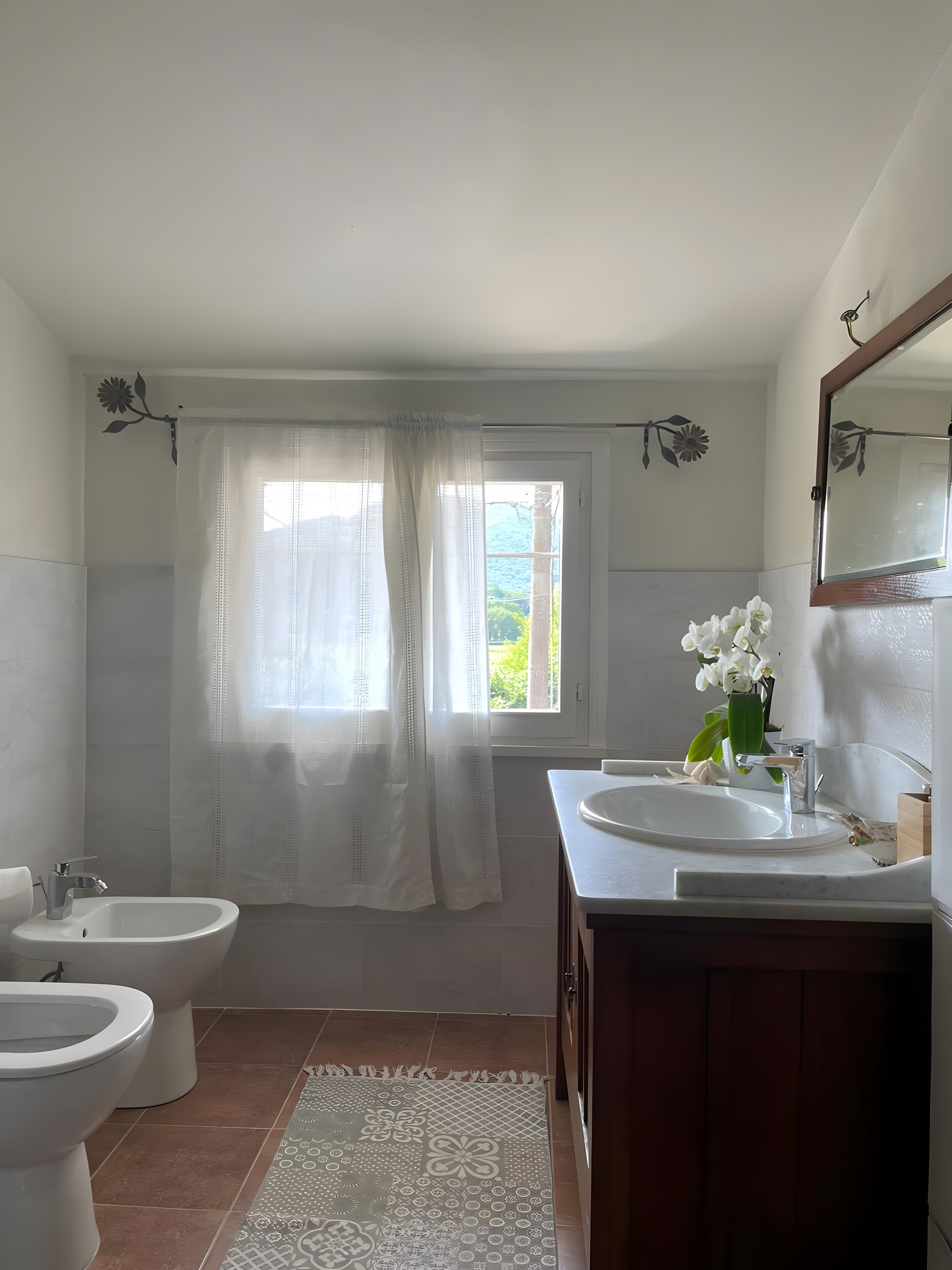 A bathroom with two sinks, a toilet, and a bidet.