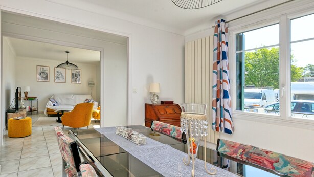 A modern living room with a glass-top dining table, a sofa, and a wooden cabinet. - Holiday Home 'Maison Ker Hélène' with Private Terrace, Wi-Fi and Air Conditioning (Guérande)
