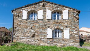 Un bâtiment en pierre doté de trois fenêtres en arc de cercle et d’une enseigne indiquant « Hôtel de la Mare ».