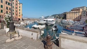 Un puerto con barcos amarrados, un muro de piedra y edificios al fondo.