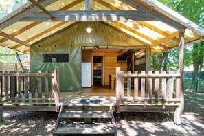 A wooden cabin with a covered porch, a kitchen area, and a small refrigerator. - Lodge 'Lodge 2' with shared pool, private terrace and communal garden (Lesperon)