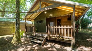 Eine Holzhütte mit Veranda, kleinem Fenster und einer Tür.