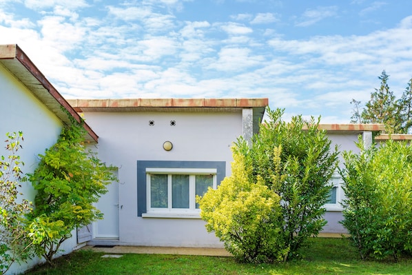 A single-story building with a white exterior, a small window, and a door.