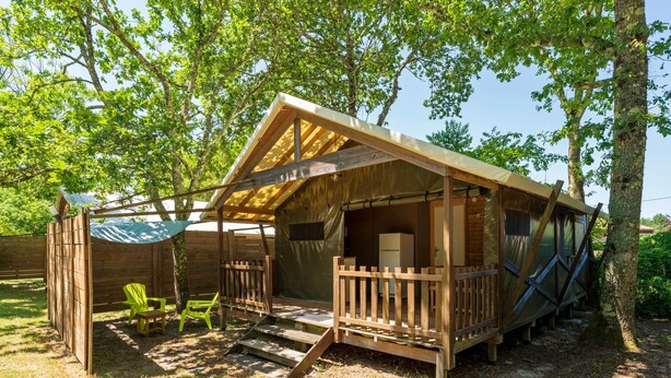 Een houten hut met een veranda, een klein terras en een overdekte zithoek.