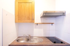 A kitchen with a stainless steel sink, wooden cabinets, and a built-in stove. - "Bruyères - Domaine Des Landes" with shared pool, private terrace, and shared garden (Lesperon)
