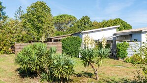 Ein modernes Haus mit weißer Fassade, umgeben von einem gepflegten Garten mit verschiedenen Pflanzen und einem Holzzaun.