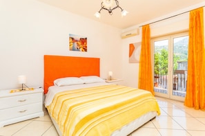 A bedroom with a bed, nightstands, a lamp, a painting, and a balcony with curtains. - Apartment 'Da Lorenzo  Alcantara' with Mountain View and Wi-Fi (Gaggi)