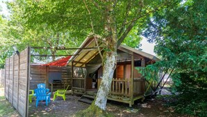 A rustic cabin with a porch, a small deck, and two chairs. - "Lodge 1" with Shared Pool, Private Terrace, and Shared Garden (Lesperon)