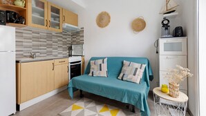 Cocina compacta con armarios de madera, microondas y cafetera.