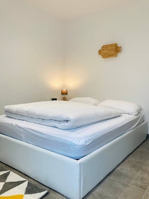 Un lit bien fait dans une pièce au design simple et épuré.