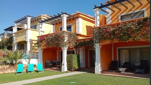 Un hôtel doté d’une terrasse, d’une pelouse bien entretenue et offrant une vue sur un ciel dégagé.