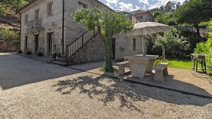 A stone building with a staircase, a bench, and a table with an umbrella. - Apartment 'E' with Mountain View, Wi-Fi and Air Conditioning (Geres)