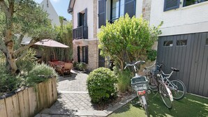Ein Innenhof mit Tisch, Stühlen, einem Fahrrad und einem kleinen Baum.