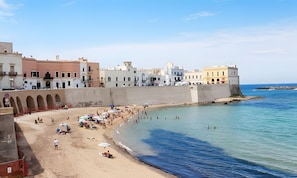 Una località balneare con spiaggia sabbiosa, un molo e edifici colorati.