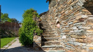 Un edificio de piedra con un estrecho camino de piedra que lo conduce.