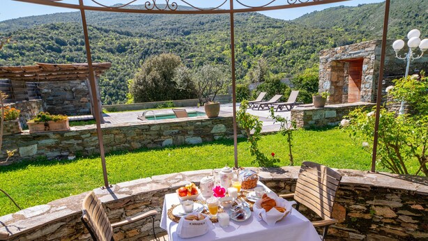 Una mesa lista para el desayuno con vista a un paisaje montañoso.