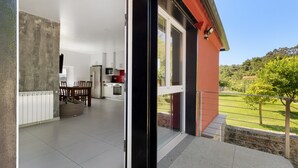 Un interior moderno con comedor, cocina y un balcón con vistas al jardín.