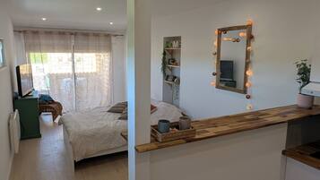 Une chambre moderne avec un grand lit, un bureau en bois et un miroir avec éclairage intégré.