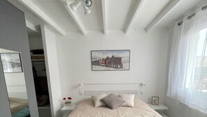 A bedroom with a bed, a ceiling fan, a picture on the wall, and a window with curtains. - Vacation home, Villa Hortense (Notre-Dame-de-Monts)