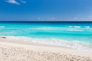 En strand med krystalklart turkisblåt vand og hvidt sand.