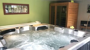 A hot tub with a wooden cabinet labeled "SPA" and a framed picture on the wall. - Le Grand Kergroas - LANNEBERT (LANNEBERT)