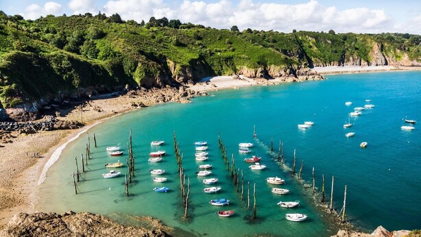 A coastal area with boats anchored near the shore, surrounded by rocky terrain and greenery. - Le Grand Kergroas - LANNEBERT (LANNEBERT)