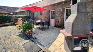A stone building with a tiled patio, outdoor seating, and a stone oven. - Le Grand Kergroas - LANNEBERT (LANNEBERT)