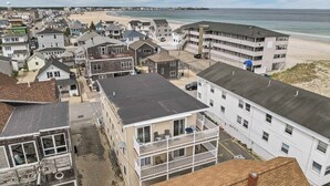A coastal hotel with multiple floors, balconies, and a beach view.