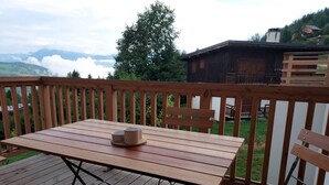 A wooden deck with a table and benches, overlooking a mountainous landscape. - Cozy apartment 6 pers, ski-in access, parking included (Valmorel)