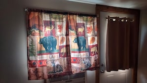 A bathroom with a window covered by a curtain featuring wildlife prints. - Charming 2-bedroom cabin in Big Clifty with WiFi, AC (Big Clifty)