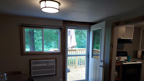 A kitchen with a wooden deck, a sliding glass door leading outside, and a built-in stove. - Charming 2-bedroom cabin in Big Clifty with WiFi, AC (Big Clifty)