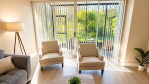 A living room with a sofa, two armchairs, a coffee table, and a potted plant. - Charming 2 BR condo with golf course views in North Tampa! Snowbirds welcome! (Tampa)
