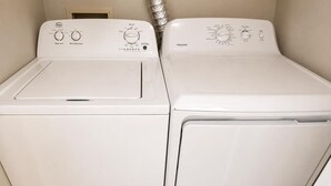 Two white front-loading washing machines side by side in a laundry room. - Charming 2 BR condo with golf course views in North Tampa! Snowbirds welcome! (Tampa)