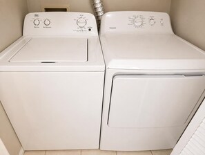 Two white front-loading washing machines side by side in a laundry room. - Charming 2 BR condo with golf course views in North Tampa! Snowbirds welcome! (Tampa)