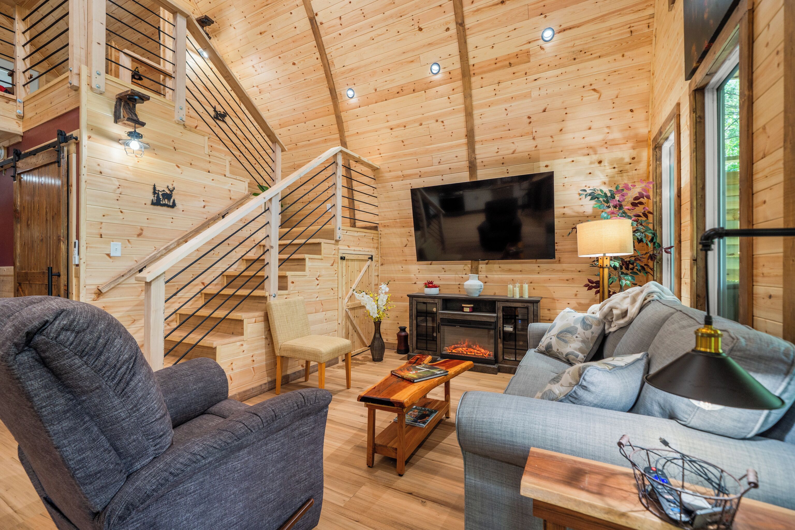 Un interior de madera con un sofá, un sillón y un televisor.
