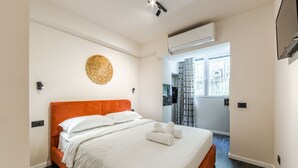 Una habitación de hotel moderna con una cama grande, un cabecero naranja y un adorno redondo en la pared.