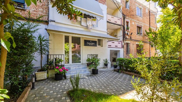 Una entrada al jardín con un cartel que dice "Garden Apartments".